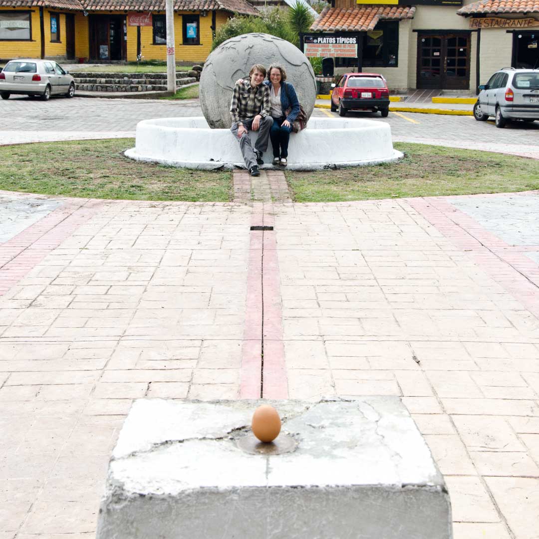 Posando con un huevo equilibrado en la auténtica Mitad del Mundo; Buena Esperanza, Cayambe, Ecuador | ©Angela Drake