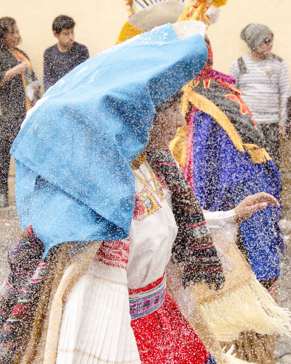 Una fina niebla de espuma de fiesta se apodera del aire alrededor de una bailarina, Guamote, Ecuador | ©Ángela Drake Carioca, Carnaval en Guamote