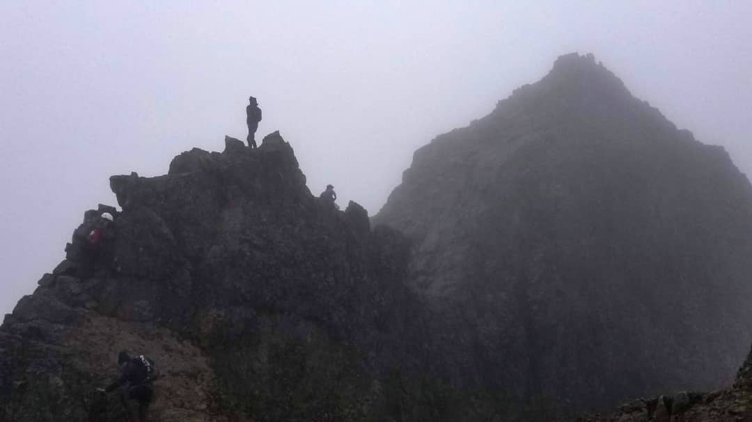 Un perfil de un excursionista en cima de la cumbre de Rucu Pichincha que está envuelto en niebla