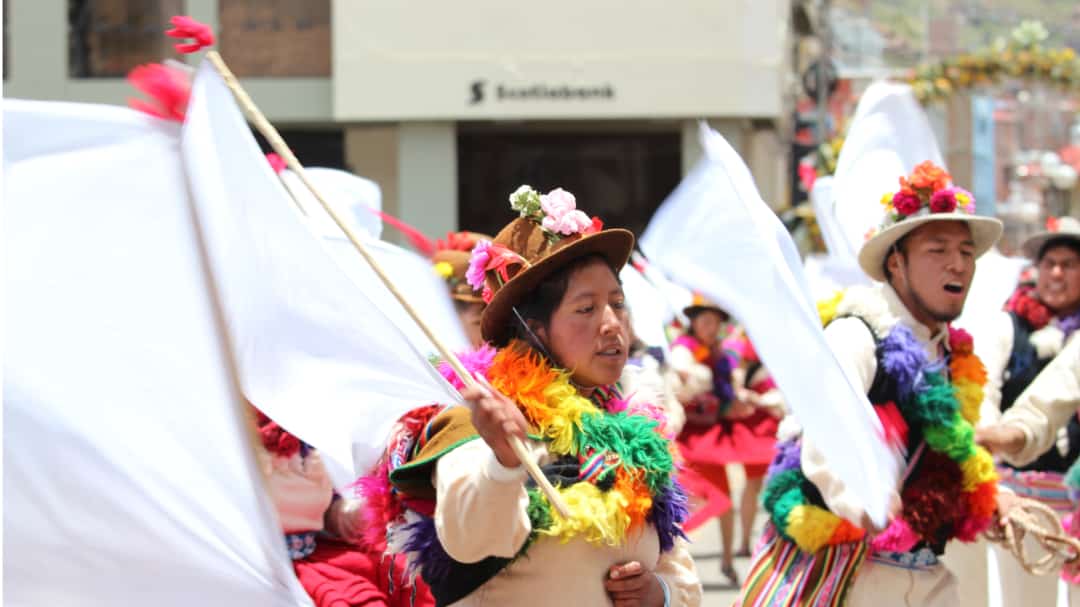 Particpantes de la procesion traen collares de brillantes colores y sombreros rusticos