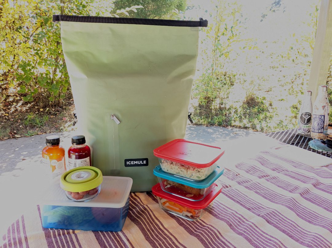 La Mochila Nevera ICEMULE con los objetos que llevaba: 2 botellas grandes de cristal, un recipiente grande de ensalada de verduras, un recipiente de hummus y tres recipientes de cristal con verduras cortadas, ensalada de salmón, etc.