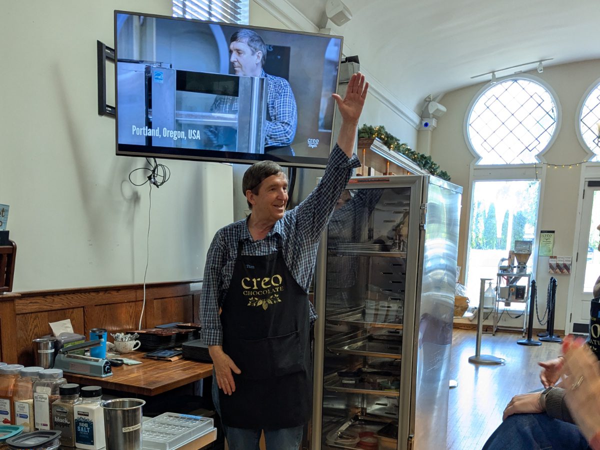 El propietario, Tim Straub, levanta la mano mientras hace una pregunta a un grupo de aprendices de chocolatero.