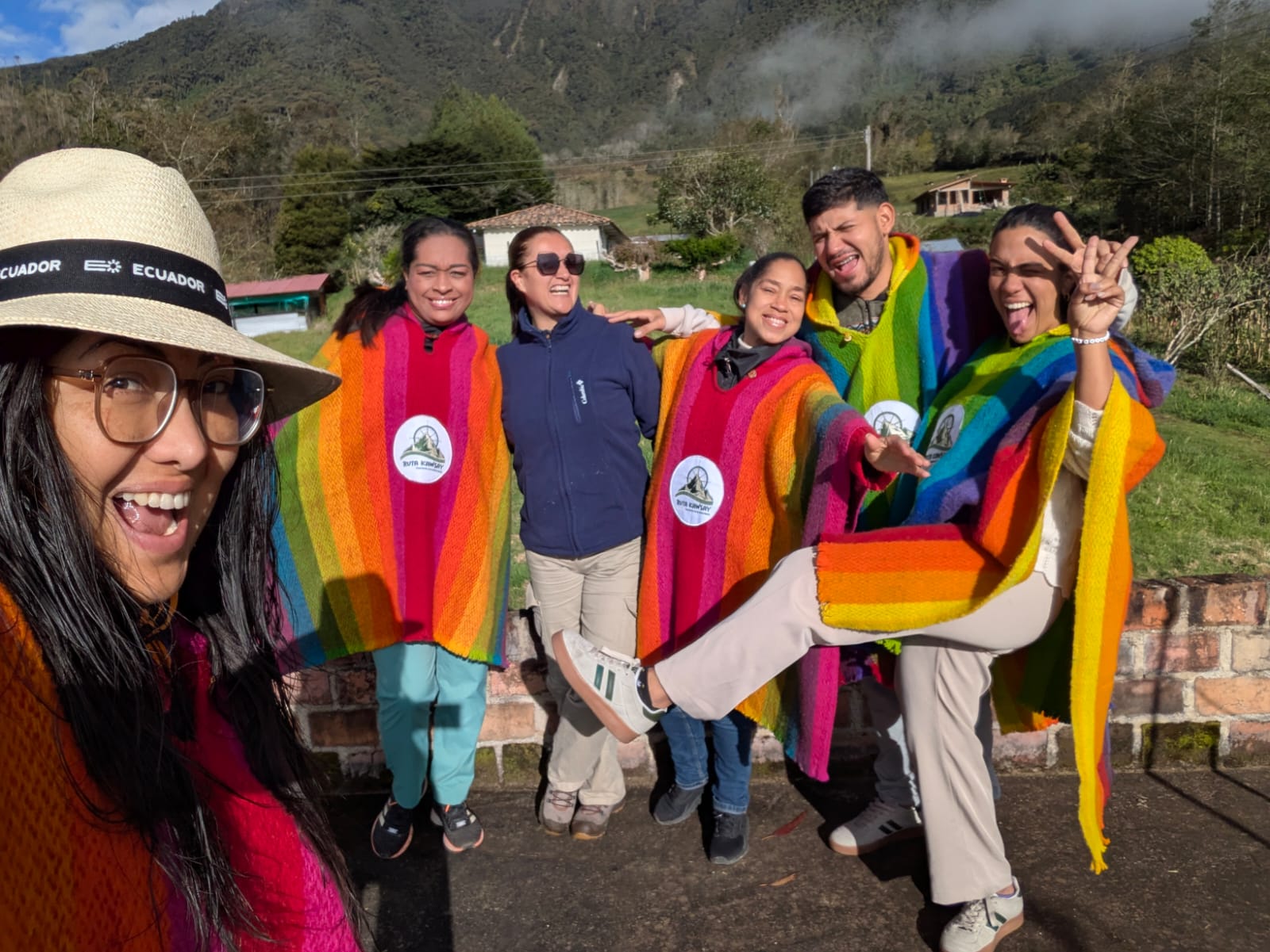 La Cocha - Colombia The author takes a selfie with five friends, most wearing rainbow striped ponchos, against a rural backdrop.
