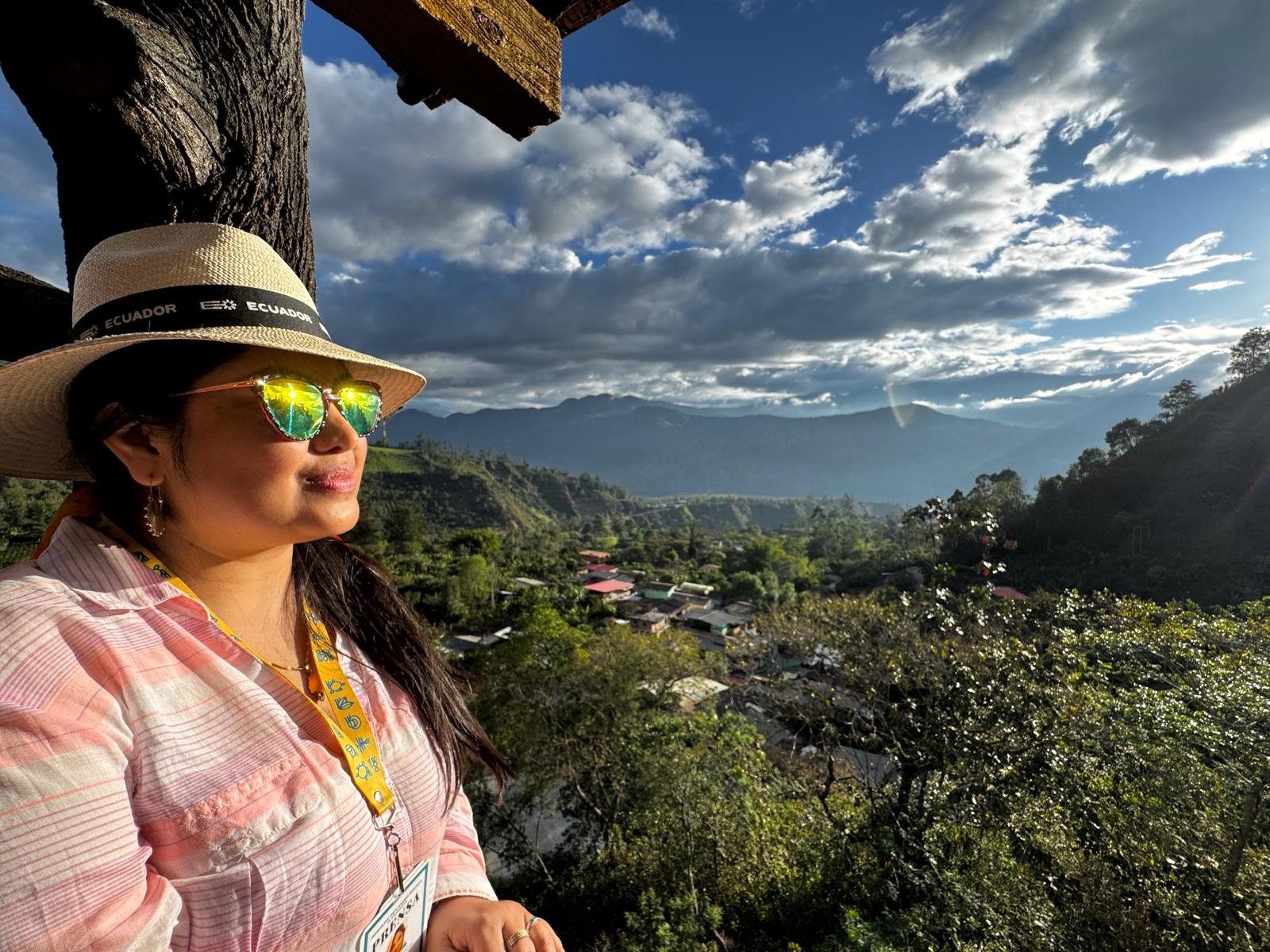 Paisaje Colombiano - Nariño The author, Jacqueline Granda, poses in sunglasses and Panama hat while looking out at a sun-filled, rural landscape of Southern Colombia in Nariño.